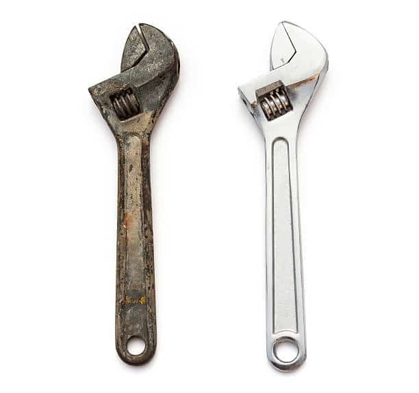 Rusty adjustable wrench next to a clean wrench showing corrosion damage and proper tool maintenance for linemen
